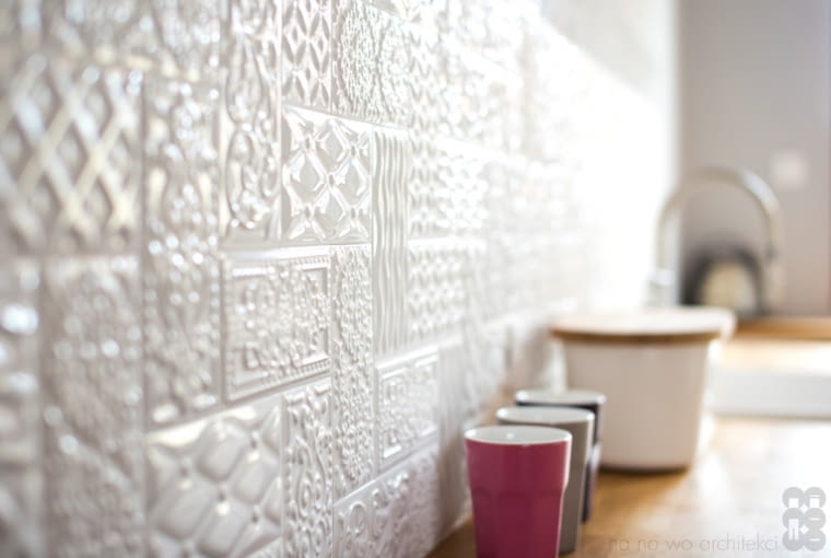 Ceramiczny zlew, podłoga w karo, drewniane dodatki, przestrzenne płytki nad blatem i materiałowe rzymskie rolety wprowadzają do kuchni przyjemny posmak retro. dom, aranżacja wnętrz, stylowe wnętrza