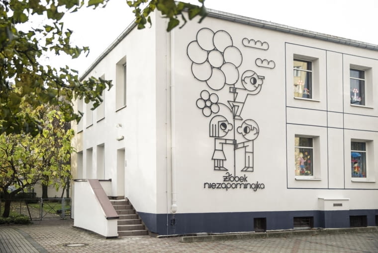 Odnowiony żłobek w Gdyni. Oszczędna w formie fasada, a na niej ilustracja metaloplastyczna zdradzająca funkcje budynku. Odnowiony żłobek w Gdyni. Oszczędna w formie fasada, a na niej ilustracja metaloplastyczna zdradzająca funkcje budynku
