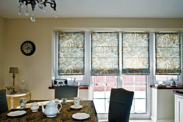 Rolety rzymskie wpiszą się w styl każdego wnętrza, pod warunkiem że wzór i rodzaj tkaniny dobrany zostanie ze smakiem. W tej rustykalnej w charakterze kuchni to się udało: okna zdobi materiał przedstawiający scenki z życia na wsi. <BR />DEKORACJE - OKNA Z ROLETĄ RZYMSKĄ. W kuchni nawiązującej wystrojem do angielskich wnętrz w oknach zawieszono rolety rzymskie uszyte z tkaniny zwanej toile de Jouy (wym. tual de żui). To płótno z sielskimi scenkami, z którego od XVIII wieku słynie francuskie miasto Jouy. Do pomieszczenia w stylu rustykalnym pasują one znakomicie.