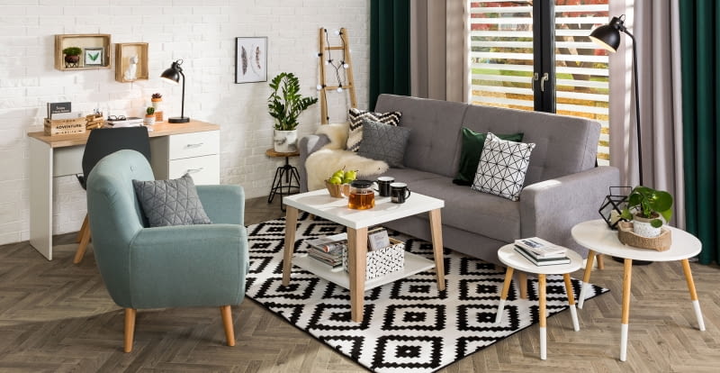 Tkaniny – dywan, zasłony, dekoracyjne poduszki, pledy i koce sprawią, że wnętrze stanie się przytulniejsze Salon w stylu hygge
