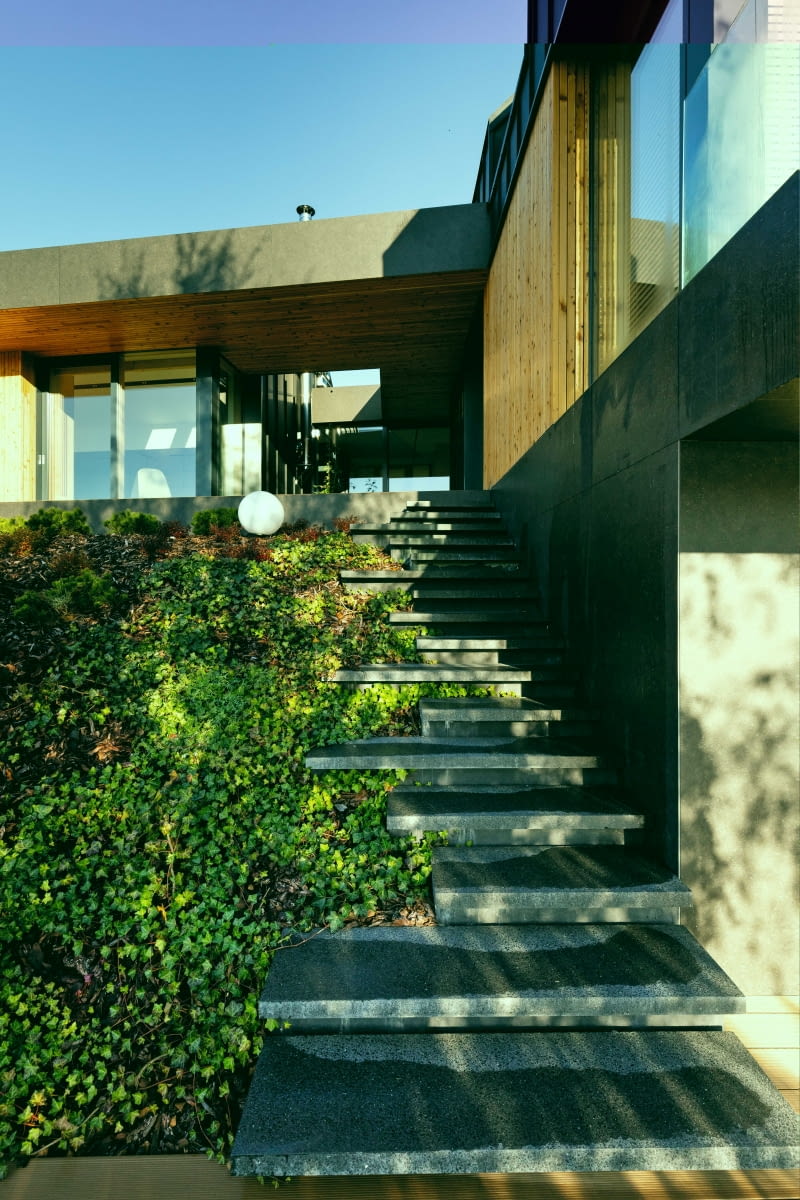 Wzdłuż styku dwóch budynków przekrytych dachem dwuspadowym, ustawionych do siebie prostopadle, powstały efektowne schody z „roztańczonych” płyt kamiennych. Można nimi wejść na poziom parteru, gdzie znajdują się tarasy widokowe