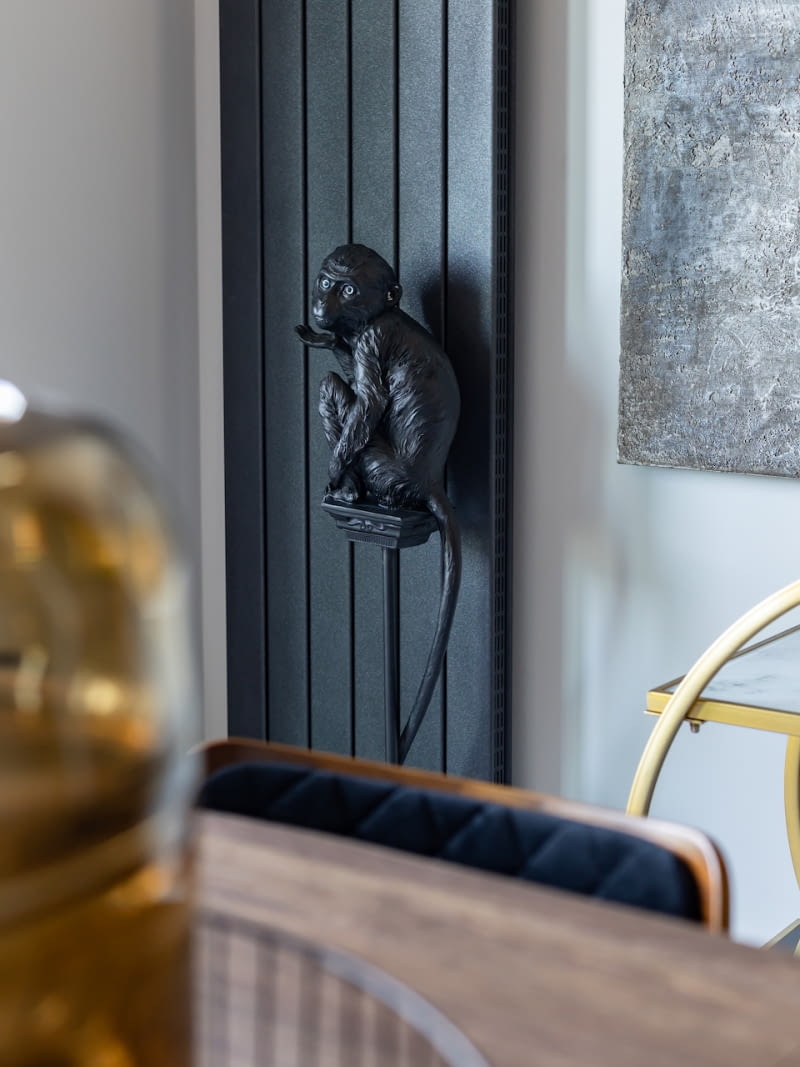 Umiejętnie skomponowane czarne powierzchnie ścian i sufitów, grzejniki, meble, żaluzje, czy dekoracje (figurka małpki – kare24.pl) wprowadzają wyrafinowany, trochę tajemniczy klimat i przykuwają uwagę.