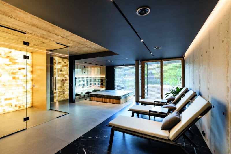 Mieć w domu saunę i jacuzzi to jedno, ale przygotować dla tych atrakcji specjalną, obszerną  przestrzeń, a w zasadzie całą kondygnację, wzbogaconą o wygodne łóżka-leżaki, głośniki  w suficie, a przede wszystkim o grotę solną – z rozjarzonych, bo podświetlanych cegieł  solnych – to już zupełnie inna skala myślenia o domowej strefie wellness-spa