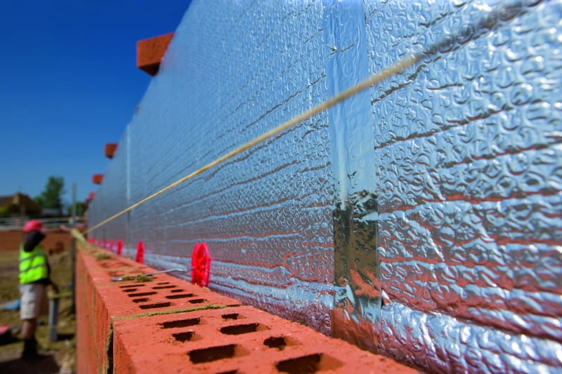 Pomiędzy ociepleniem a warstwą osłonową zaleca się pozostawienie niewielkiej pustki powietrznej. Tak wykonaną ścianę określa się czasem mianem czterowarstwowej, jednak faktycznie jest to po prostu ściana trójwarstwowa ze szczeliną wentylacyjną Pomiędzy ociepleniem a warstwą osłonową zaleca się pozostawienie niewielkiej pustki powietrznej. Tak wykonaną ścianę określa się czasem mianem czterowarstwowej, jednak faktycznie jest to po prostu ściana trójwarstwowa ze szczeliną wentylacyjną