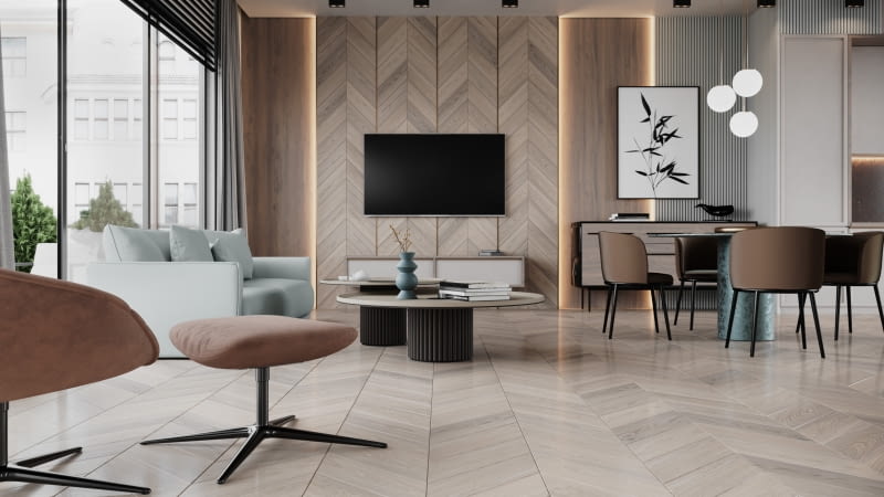 Płynnie przechodzące z podłogi na ścianę deski Chevron Dąb Caldo wyglądają tak spektakularnie, że odwracają uwagę od czarnego ekranu telewizora.