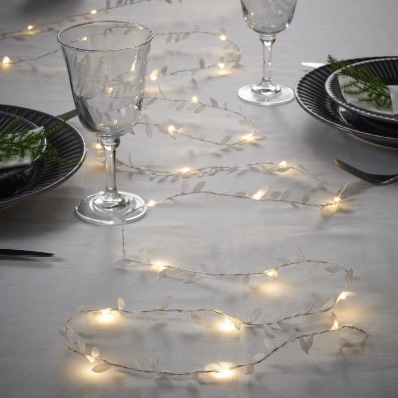 Zamiast bogatych, kolorowych dekoracji ułóż na stole łańcuch ledowy. Po zapaleniu da delikatne światło. ikea.pl