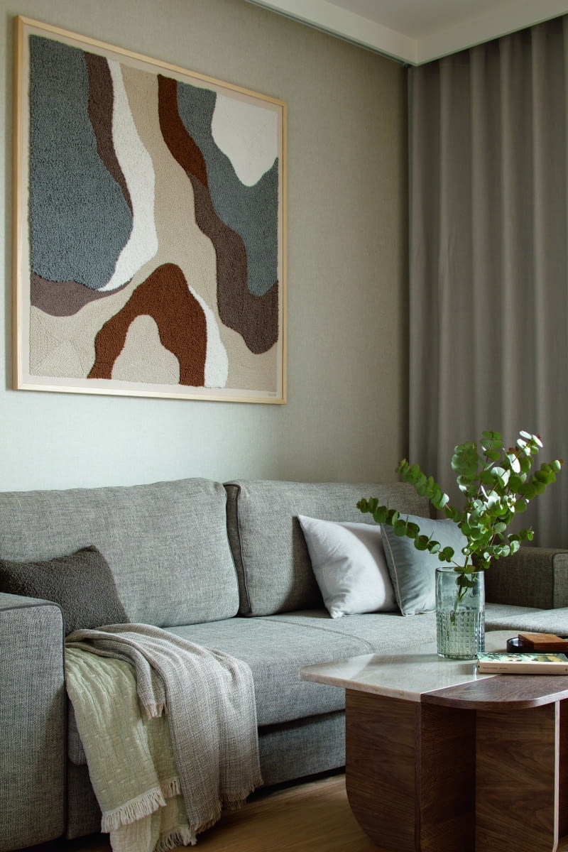 W salonie uwagę przyciąga obraz z pracowni Siena Paloma wykonany na zamówienie techniką punch needle, który ożywia spokojną paletę brązów i beżów. Towarzyszą mu zróżnicowane faktury: grubo tkana tapicerka sofy Aris, struktura płótna na tapecie i zasłonkach oraz rysunek drewna i kamienia widoczny na stoliku kawowym. W salonie uwagę przyciąga obraz z pracowni Siena Paloma wykonany na zamówienie techniką punch needle, który ożywia spokojną paletę brązów i beżów. Towarzyszą mu zróżnicowane faktury: grubo tkana tapicerka sofy Aris, struktura płótna na tapecie i zasłonkach oraz rysunek drewna i kamienia widoczny na stoliku kawowym.