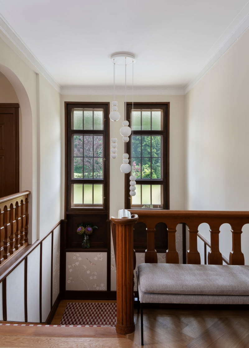 Willa w stylu secesyjnym niedaleko Zurychu: w okazałym holu wejściowym czekają na gości wspaniałe schody i ręcznie malowana lniana tapeta z motywem kwiatowym i ptakami.