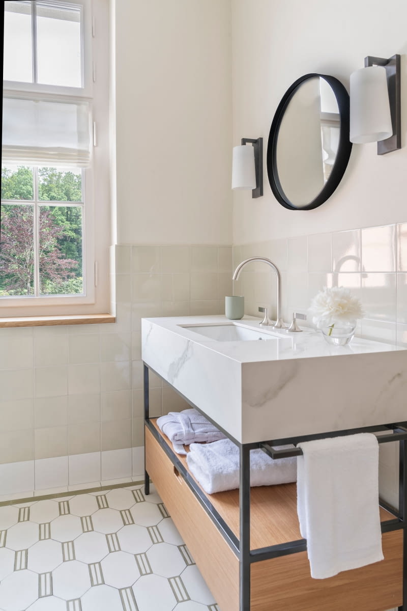 Vaia w kolorze Brushed Platinum łączy tradycyjną elegancję z przejrzystością i otwartością. Armatura Dornbracht harmonijnie wtapia się w minimalistyczną architekturę łazienki.