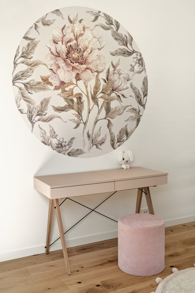 Pokoje córek zaprojektowano, stosując tę samą bazę kolorystyczną, która jest obecna w całym domu: naturalne drewno dębowe, jasne odcienie bieli i szarości. W królestwie kilkuletnich dziewczynek pojawiły się też przyjemne, pastelowe akcenty w postaci naklejek na ścianach, które gdy córki podrosną, można będzie łatwo wymienić. Okrągła naklejka w peonie jest ze sklepu dekornik.com., a toaletka w kolorze zgaszonego różu z minko.co.