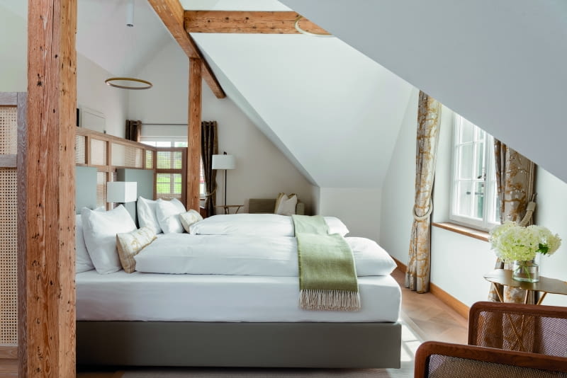 Nowoczesne elementy, takie jak minimalistyczne, pierścieniowe lampy wiszące, tworzą celowe kontrasty.