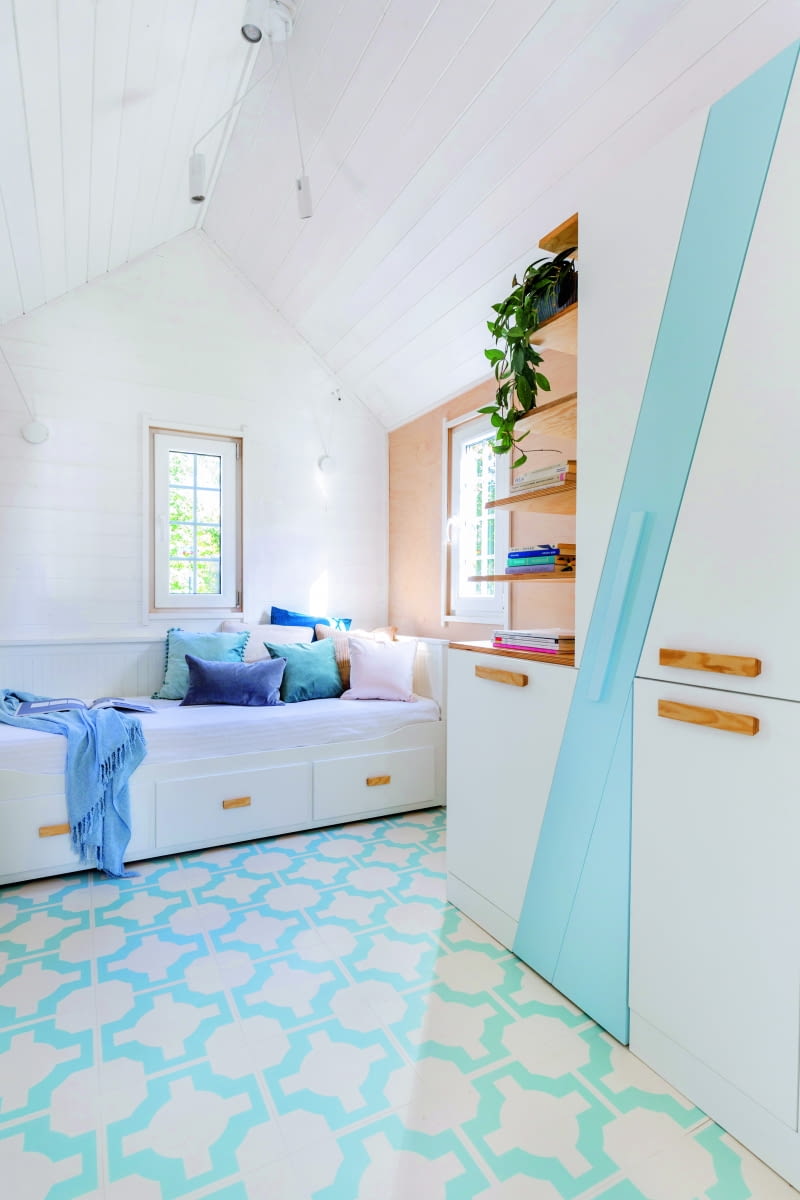 W głębi domku, na parterze ustawiono dużą, rozkładaną sofę, na której wygodnie mogą spać dwie osoby. Na podłodze ułożone zostały panele winylowe LVT HARVEY MARIA, które są nie tylko ładne, niedrogie i wodoodporne, ale też lekkie – co ma znaczenie w przypadku domu na kółkach