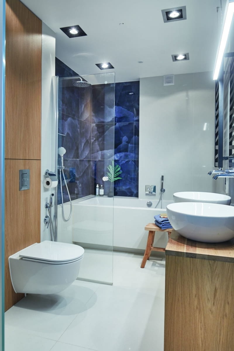 Prysznic był obowiązkowym wyposażeniem łazienki dla Hanny i Łukasza, ale przy zachowaniu wanny, co nie było łatwe do zaplanowania w niedużym pomieszczeniu. Architektka zaproponowała więc nietypowe rozwiązanie, w którym długą i wąską wannę poprzedza strefa prysznica, ale bez kabiny, jedynie z ruchomą ścianką. W momencie korzystania z prysznica jest on wydzielony taflą szkła, a kiedy jest nieużywany, ruchome skrzydło zostaje odłożone na ścianę.