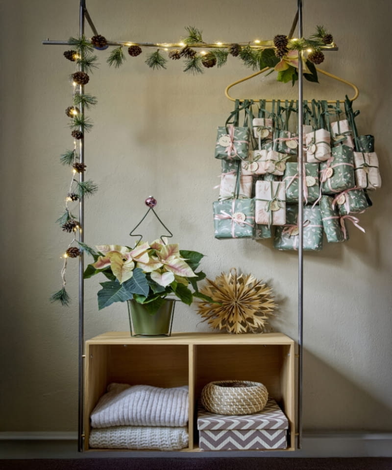 Ręcznie wykonany kalendarz adwentowy w subtelnych odcieniach zieleni i różu stanowi dekoracyjny akcent na wieszaku na ubrania. Zawieszone na nim pięknie zapakowane prezenty budzą radość i zapowiadają wyjątkowy, świąteczny czas. Ręcznie wykonany kalendarz adwentowy w subtelnych odcieniach zieleni i różu stanowi dekoracyjny akcent na wieszaku na ubrania. Zawieszone na nim pięknie zapakowane prezenty budzą radość i zapowiadają wyjątkowy, świąteczny czas.