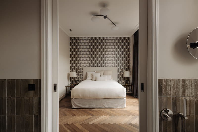 Projekt łazienki jest precyzyjnie dopasowany do sąsiedniej sypialni, co daje spójną i harmonijną kompozycję.