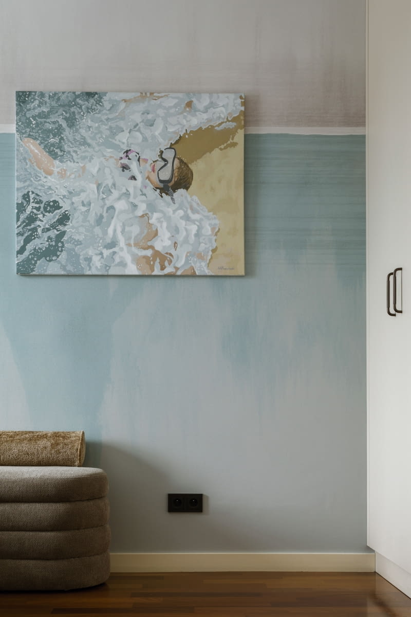 Ścianę naprzeciwko łóżka zdobi tapeta w błękitnym kolorze. Barwa idealnie komponuje się z obrazem Michała Przewłockiego, który pochodzi z kolekcji sztuki właścicieli.