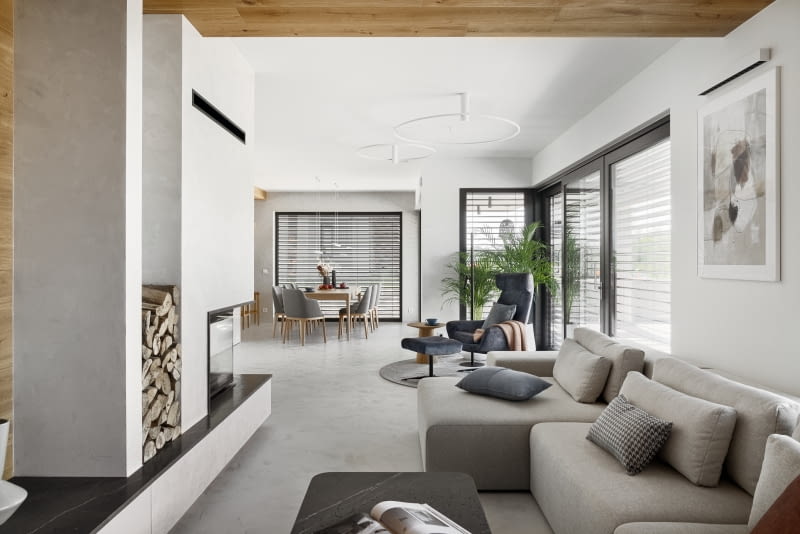 Przestronna, jasna, dzięki przyjętej aranżacji i dużym oknom, część dzienna jest spełnieniem marzeń domowników o wygodnej, nieprzeładowanej wyposażeniem strefie rodzinnej.