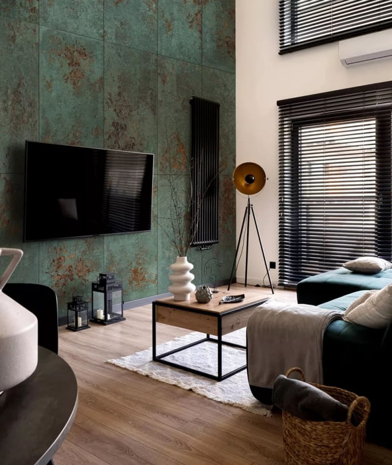 Wpadające w kojącą zieleń betonowe płyty z efektem cortenowskiej rdzy kamuflują czarny odbiornik.