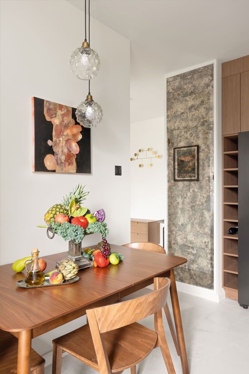 W kuchni uwagę przyciąga panel postarzanego szkła przy wejściu, który optycznie powiększa przestrzeń i odbija światło. Stół i krzesła to produkty marki Zuiver, a wiszące lampy Dutchhouse. Ścianę zdobi obraz Oli Munzar. W kuchni uwagę przyciąga panel postarzanego szkła przy wejściu, który optycznie powiększa przestrzeń i odbija światło. Stół i krzesła to produkty marki Zuiver, a wiszące lampy Dutchhouse. Ścianę zdobi obraz Oli Munzar.