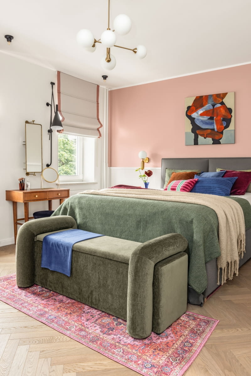 W sypialni architektka połączyła nowe wyposażenie z elementami, które właściciele zabrali z poprzedniego mieszkania: z nowoczesnym szarym łóżkiem z Fabryki Sypialni oraz konsolą i szafkami nocnymi marki Pasform, inspirowanymi estetyką PRL-u. Do zestawu dołączył wymarzony „perski” dywan. Całość tworzy spójną, barwną przestrzeń pełną pozytywnej energii. W sypialni architektka połączyła nowe wyposażenie z elementami, które właściciele zabrali z poprzedniego mieszkania: z nowoczesnym szarym łóżkiem z Fabryki Sypialni oraz konsolą i szafkami nocnymi marki Pasform, inspirowanymi estetyką PRL-u. Do zestawu dołączył wymarzony „perski” dywan. Całość tworzy spójną, barwną przestrzeń pełną pozytywnej energii.