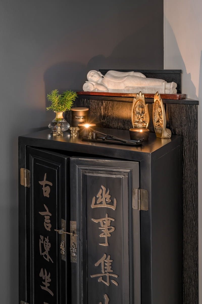 W rogu, za telewizorem stanęła chińska szafka, którą Marta dopasowała do wnętrza. Mebel był oryginalnie czerwony z czarnym napisem. Stolarz przemalował go na czarno, a artystka zmieniła napisom kolor na stare złoto.