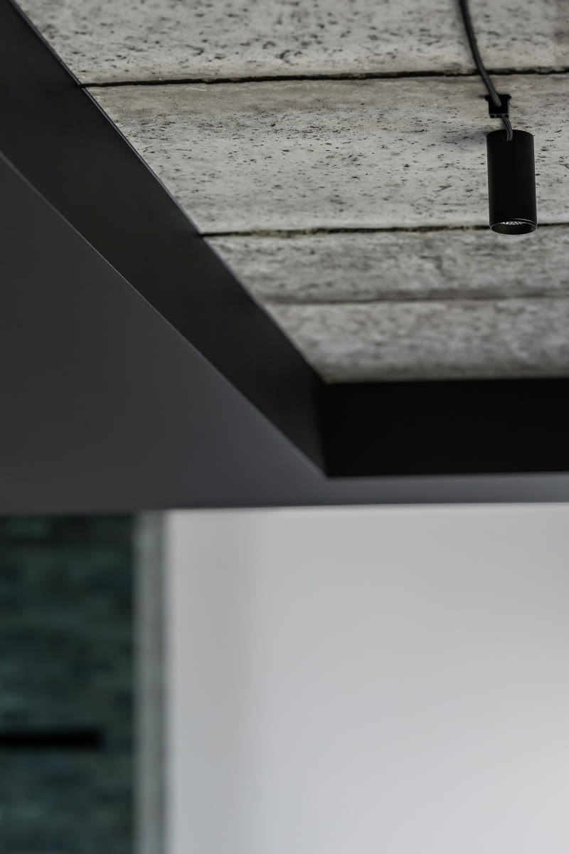 W przedsionku i w korytarzu na parterze pozostawiono odsłonięty, nieotynkowany strop betonowy. To rozwiązanie, zaproponowane przez Dominikę Cymerman, idealnie wpisało się w oczekiwania Anny i Łukasza, którym zależało na jak najczęstszym stosowaniu autentycznych materiałów. Przyjętą estetykę aranżacji uzupełnia sąsiedztwo czarnych powierzchni, technicznych opraw oświetleniowych i kabli prowadzonych po wierzchu płyt stropowych. W przedsionku i w korytarzu na parterze pozostawiono odsłonięty, nieotynkowany strop betonowy. To rozwiązanie, zaproponowane przez Dominikę Cymerman, idealnie wpisało się w oczekiwania Anny i Łukasza, którym zależało na jak najczęstszym stosowaniu autentycznych materiałów. Przyjętą estetykę aranżacji uzupełnia sąsiedztwo czarnych powierzchni, technicznych opraw oświetleniowych i kabli prowadzonych po wierzchu płyt stropowych.