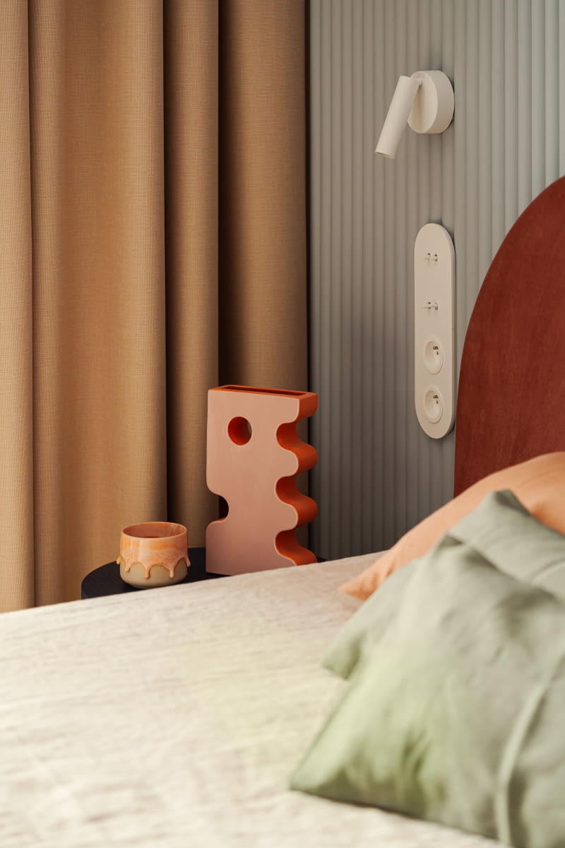Przy łóżku ceramiczny wazon marki Pani Jurek i kubek od MUAS Ceramics.
