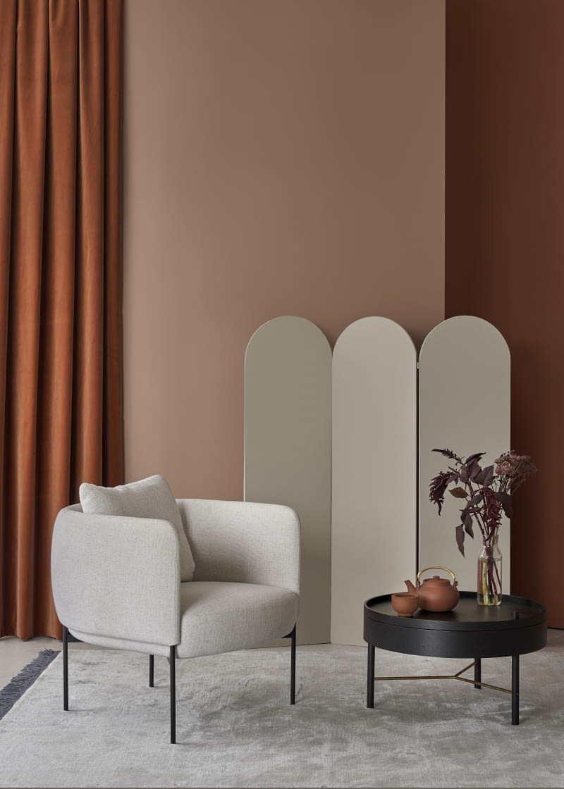 Relaksujący kącik w kolorze delikatnej terakoty. Barwa ścian, a także smukłe linie fotela na wysokich nóżkach podkreślają nowoczesny wystrój kompozycji.