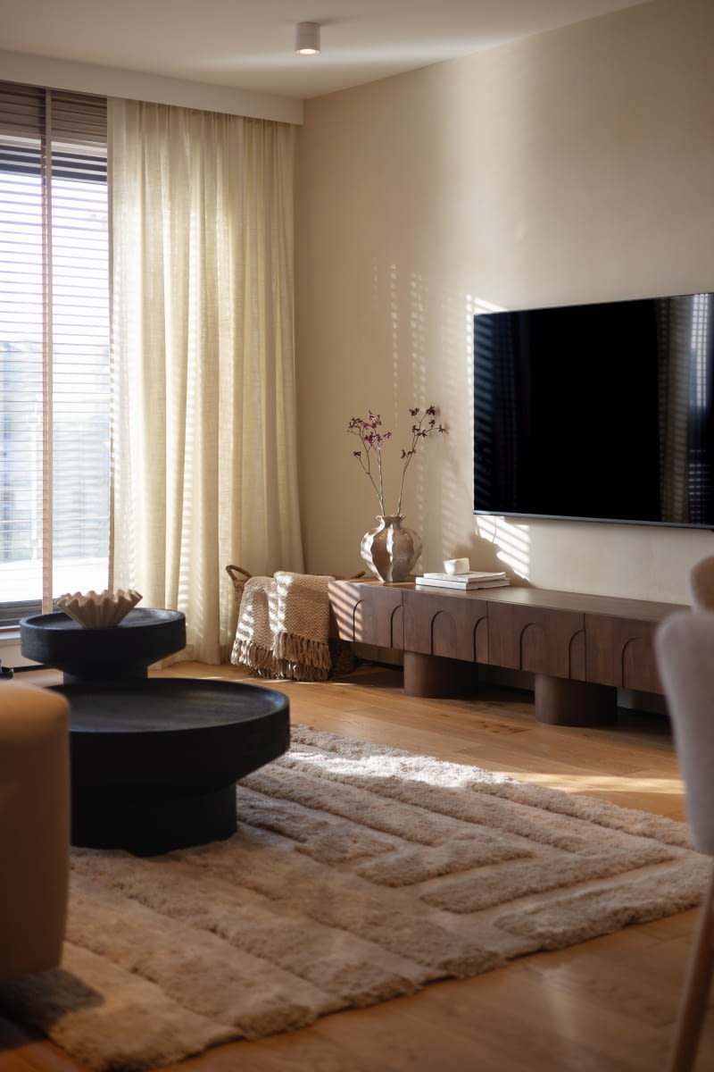 Nowoczesny, przyjazny wystrój mieszkania stanowi spokojne tło, na którym wybrzmiewają akcenty boho – jedne  z ulubionych pani domu. Styl pojawia się tu z umiarem, widoczny jedynie  w lampach, tapecie w sypialni czy  w postaci glinianego tynku ze sklepu Santerra, którym wykończono ścianę pod telewizorem.