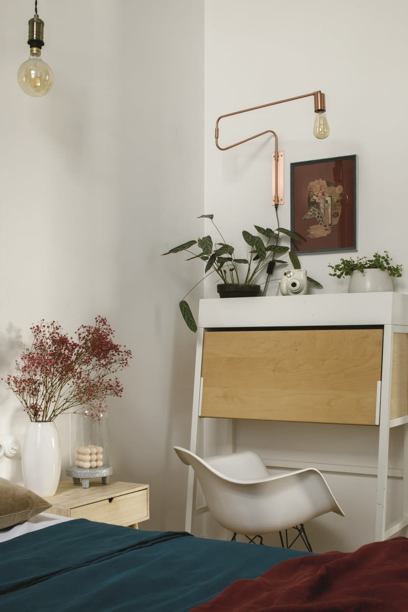 W sypialni wygospodarowano kącik do pracy. Zestawiono tu białe biurko z Ikea – w formie sekretarzyka z zamykanym drewnianym frontem – z białym krzesłem o organicznym kształcie na czarnych, metalowych nogach. Wnętrze uzupełniają industrialne lampy: miedziany kinkiet nad biurkiem oraz wiszące żarówki. Na ścianie wyeksponowano kolaż Aleksandry Morawiec. W tym eklektycznym mieszkaniu motywy stylistyki skandynawskiej, loftowej i retro przewijają się w każdym zakątku. W sypialni wygospodarowano kącik do pracy. Zestawiono tu białe biurko z Ikea – w formie sekretarzyka z zamykanym drewnianym frontem – z białym krzesłem o organicznym kształcie na czarnych, metalowych nogach. Wnętrze uzupełniają industrialne lampy: miedziany kinkiet nad biurkiem oraz wiszące żarówki. Na ścianie wyeksponowano kolaż Aleksandry Morawiec. W tym eklektycznym mieszkaniu motywy stylistyki skandynawskiej, loftowej i retro przewijają się w każdym zakątku.