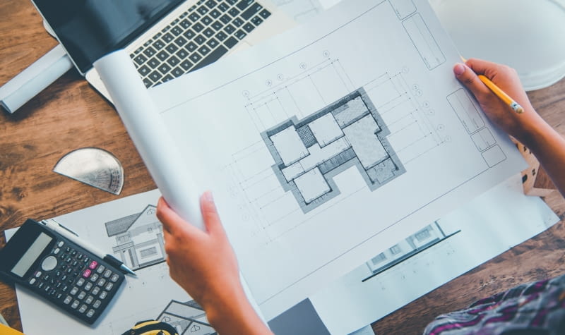 Przystosowanie projektu domu do wąskiego terenu nie musi oznaczać zmniejszenia metrażu. Niektóre domy mają sporą powierzchnię, rekompensując ograniczoną szerokość działki liczbą kondygnacji