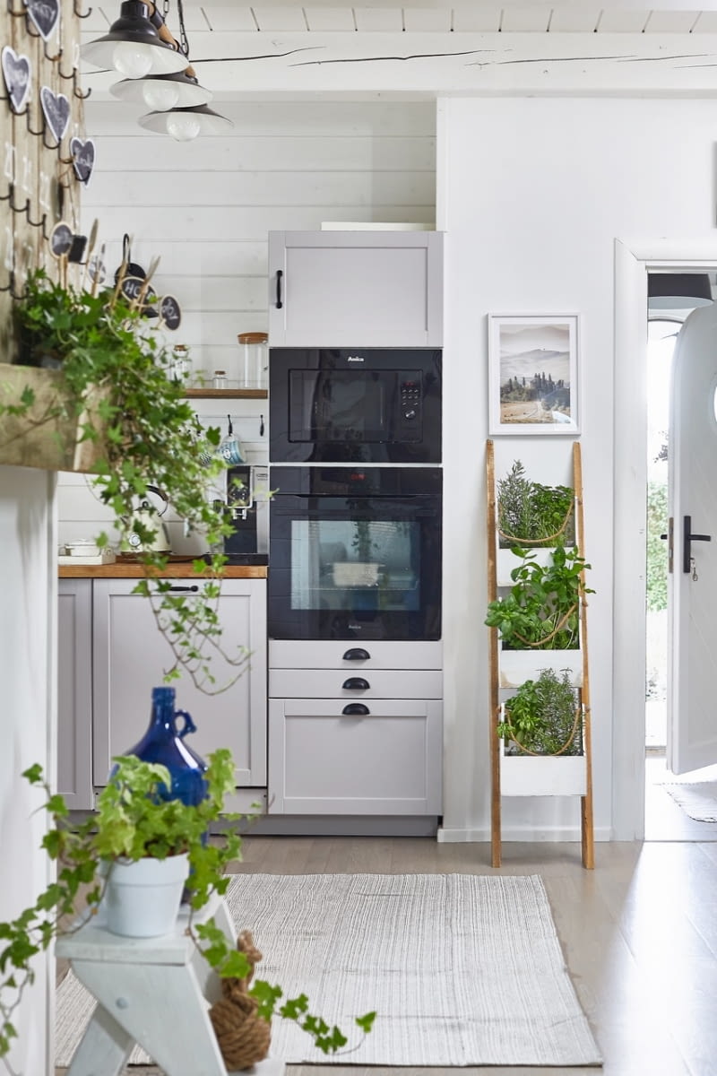 Rozkład mebli kuchennych gospodarze zaprojektowali samodzielnie, korzystając z programu do planowania na stronie internetowej Ikei. Tutaj też je kupili, łącznie  z drewnianym blatem i stylizowanymi, czarnymi uchwytami. Na wzór skandynawskich  wnętrz, na kuchennej podłodze zagościł tkany ręcznie chodnik.