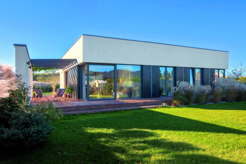 Zdaniem inwestorów, w projekcie, jaki wyszedł spod ręki architektki Izabeli Markowskiej z pracowni 3DPROJEKT, jest wręcz więcej przeszkleń niż ścian – widać to w elewacji ogrodowej, zaopatrzonej w duże, tarasowe okna, doświetlające część dzienną (po lewej) Zdaniem inwestorów, w projekcie, jaki wyszedł spod ręki architektki Izabeli Markowskiej z pracowni 3DPROJEKT, jest wręcz więcej przeszkleń niż ścian – widać to w elewacji ogrodowej, zaopatrzonej w duże, tarasowe okna, doświetlające część dzienną (po lewej)
