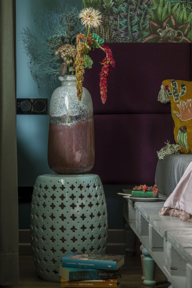 Ceramiczne, szkliwione stoliki w błękicie z kroplą turkusu wpisują się w paletę barw sypialni, a ich ażurowe wycięcia w formie marokańskiej koniczynki podkreślają obecne  w całym domu orientalne odniesienia.
