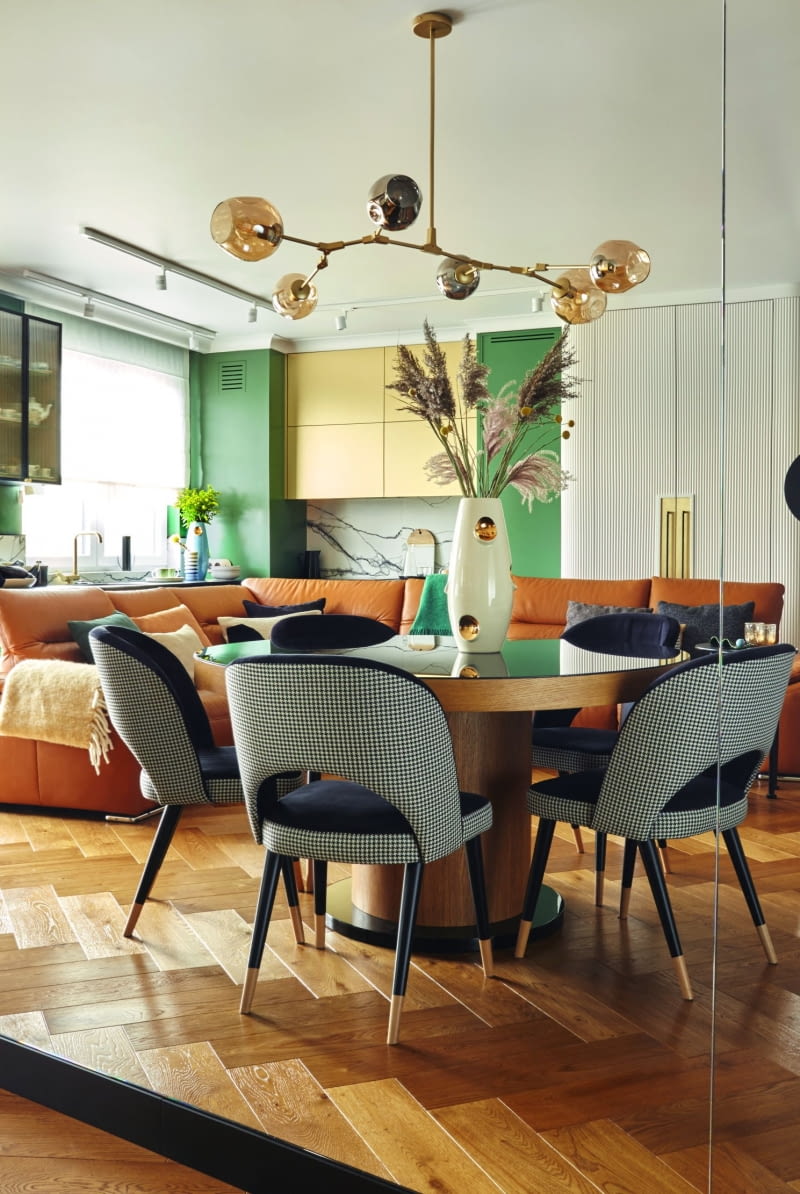 W lustrzanej ścianie odbija się widok na salon i kuchnię. Dzięki temu rozwiązaniu ściana przy której stanęło pianino i w bliskiej odległości stół, wydaje się „oddalać” od reszty pomieszczenia. Przestrzeń strefy dziennej sprawia wrażenie znacznie większej niż jest w rzeczywistości.