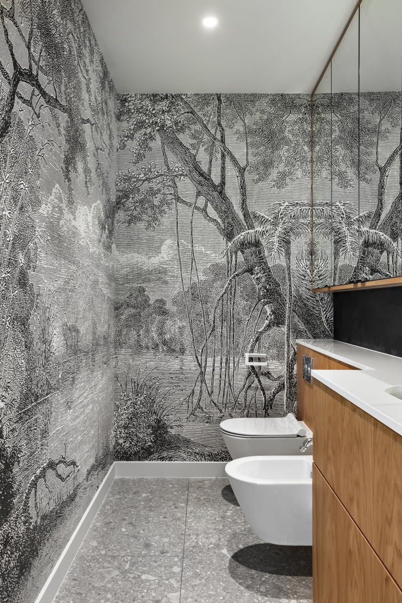 Wydłużone proporcje toalety gościnnej równoważą lustrzane fronty szafek, których tafle efektownie multiplikują dekoracyjny efekt czarno białej tapety włoskiej marki Inkiostro Bianco. Wydłużone proporcje toalety gościnnej równoważą lustrzane fronty szafek, których tafle efektownie multiplikują dekoracyjny efekt czarno białej tapety włoskiej marki Inkiostro Bianco.