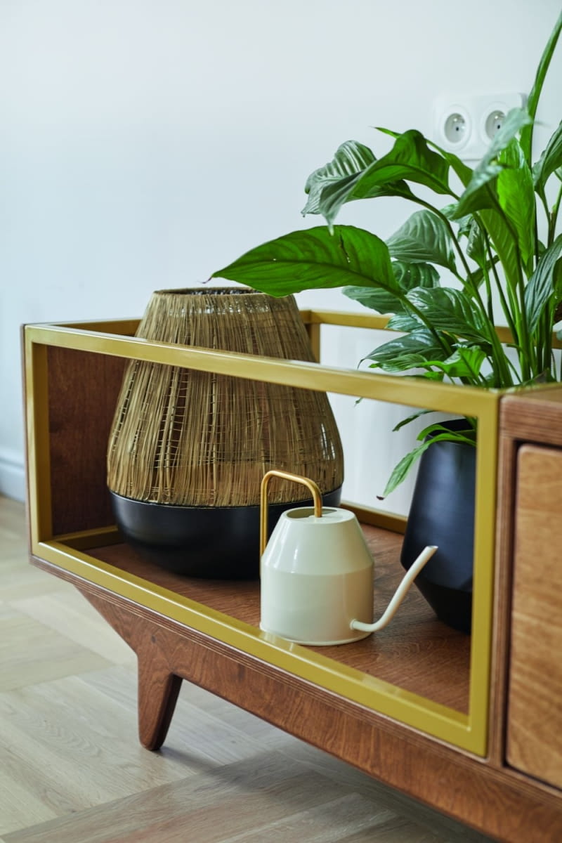 Pośród niezbędnych, zaprojektowanych przez architektkę mebli do zabudowy – szaf i regałów na książki – uwagę zwracają wolno stojące meble. Stolik kawowy i szafka RTV pochodzą z manufaktury Wood Republic. Inspirowane latami 70., powstały ze sklejki brzozowej wykończonej, dobranym specjalnie na życzenie, ciemnym odcieniem wosku olejnego.