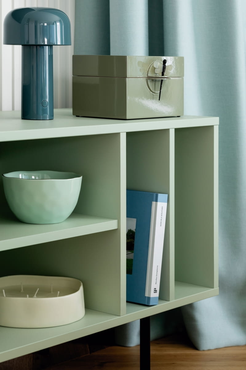 W części dziennej dominują błękity, beże i odcienie szałwii. Pod telewizorem stanęła szafka z lectus24.pl w delikatnej zieleni. Na półkach: pojemnik z ważką i niebieska lampka Flos z Comforty. W części dziennej dominują błękity, beże i odcienie szałwii. Pod telewizorem stanęła szafka z lectus24.pl w delikatnej zieleni. Na półkach: pojemnik z ważką i niebieska lampka Flos z Comforty.