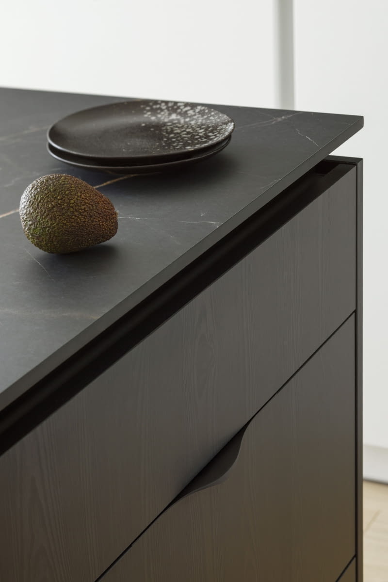 Sposób montażu blatu na na wyspie kuchennej z pod-cięciem tworzy efekt „unoszenia się”. To jeden z subtelnych detali, który szczególnie lubi w tym projekcie architektka Katarzyna Sosińska. Blat wykonano z laminatu HPL.