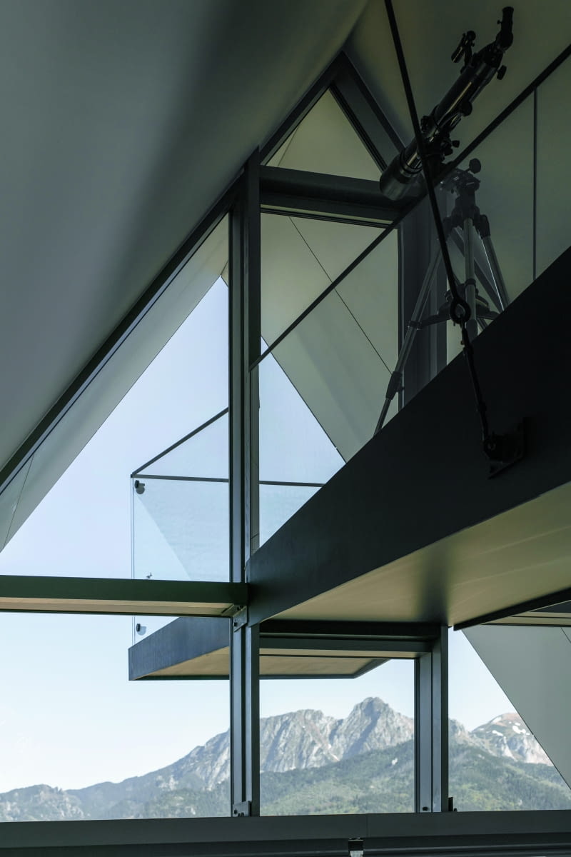 Zakończenie kładki, widziane od strony wnętrza, czyli ostatnich dwóch kondygnacji – jej konstrukcję nośną ukryto w ślusarce okiennej przeszklonej ściany szczytowej Zakończenie kładki, widziane od strony wnętrza, czyli ostatnich dwóch kondygnacji – jej konstrukcję nośną ukryto w ślusarce okiennej przeszklonej ściany szczytowej