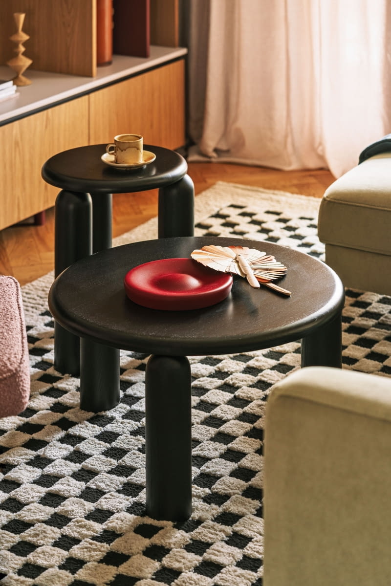 Na blacie jednego ze stolików kawowych od Tamo ułożono czerwoną, drewnianą tacę z Eisku i wachlarz z NAP.