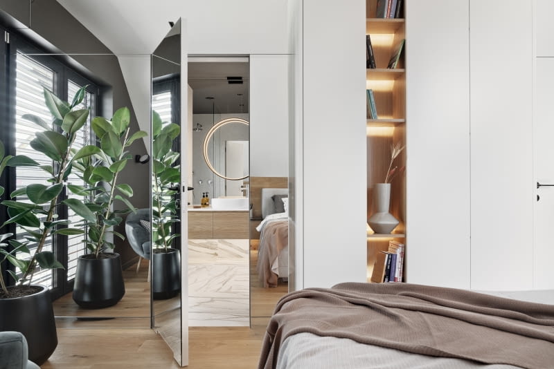 Ściana z drzwiami prowadzącymi do łazienki rodziców została wykończona lustrem, co nadaje pomieszczeniu głębi. Potęguje też wrażenie, że sąsiadujące z lustrami pionowe okno jest szersze niż w rzeczywistości.