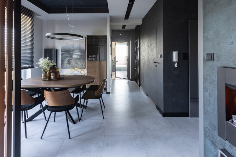 Otwarta strefa dzienna, która łączy hol wejściowy z jadalnią, kuchnią i salonem, daje wrażenie wygody i przestronności. Spójną aranżację osiągnięto poprzez wykorzystanie zbliżonej palety kolorów i materiałów we wszystkich jej częściach.