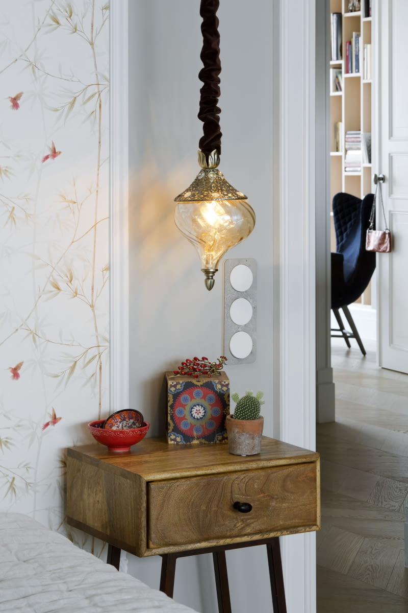 Nad szafką nocną Skybox marki Woood kupioną w Zona Design wiszą charakterystyczne lampy model „Harem” producenta Ideal Lux. Zostały delikatnie zmodyfikowane – przedłużone i uzupełnione o tekstylne detale szyte na zamówienie. W całym mieszkaniu zastosowano osprzęt elektryczny marki Berker z betonowymi ramkami. Nad szafką nocną Skybox marki Woood kupioną w Zona Design wiszą charakterystyczne lampy model „Harem” producenta Ideal Lux. Zostały delikatnie zmodyfikowane – przedłużone i uzupełnione o tekstylne detale szyte na zamówienie. W całym mieszkaniu zastosowano osprzęt elektryczny marki Berker z betonowymi ramkami.