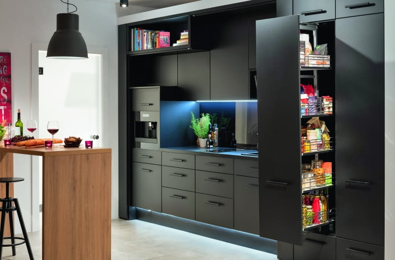 Po rozsunięciu drzwi ukazuje się wygodna, w pełni wyposażona kuchnia z dużą strefą do przechowywania produktów i akcesoriów kuchennych.