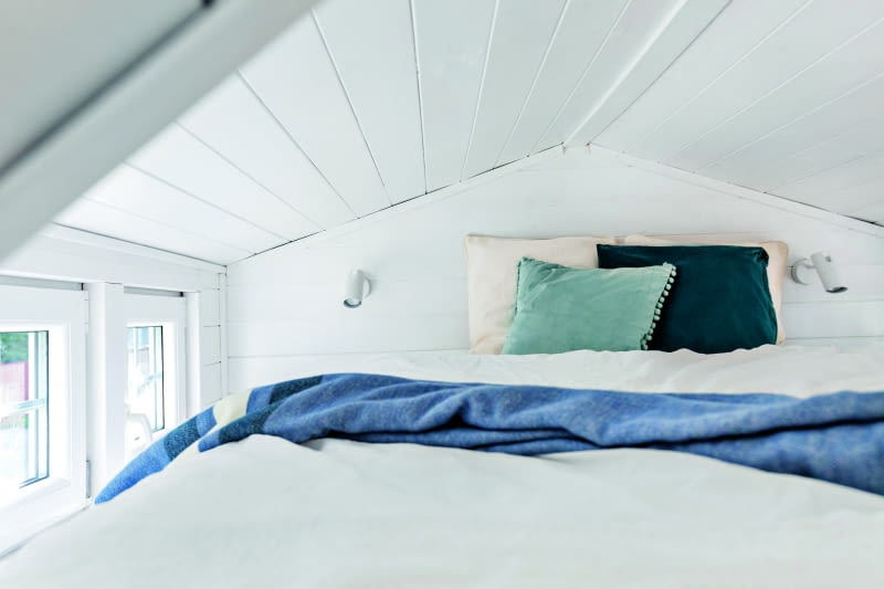 Na antresoli umieszczono sypialnię, z wygodnym materacem i lampkami do czytania. Wystarczy wyciągnąć rękę, by – nie wstając nawet z łóżka – zamknąć lub otworzyć okna.