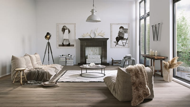 Niebanalna aranżacja wywołuje emocje za sprawą imitacji kominka i tego co wokół niego. Umieszczony w centralnym miejscu portal kominkowy zdobią zawieszone po bokach fotografie-portrety mieszkańców domu.