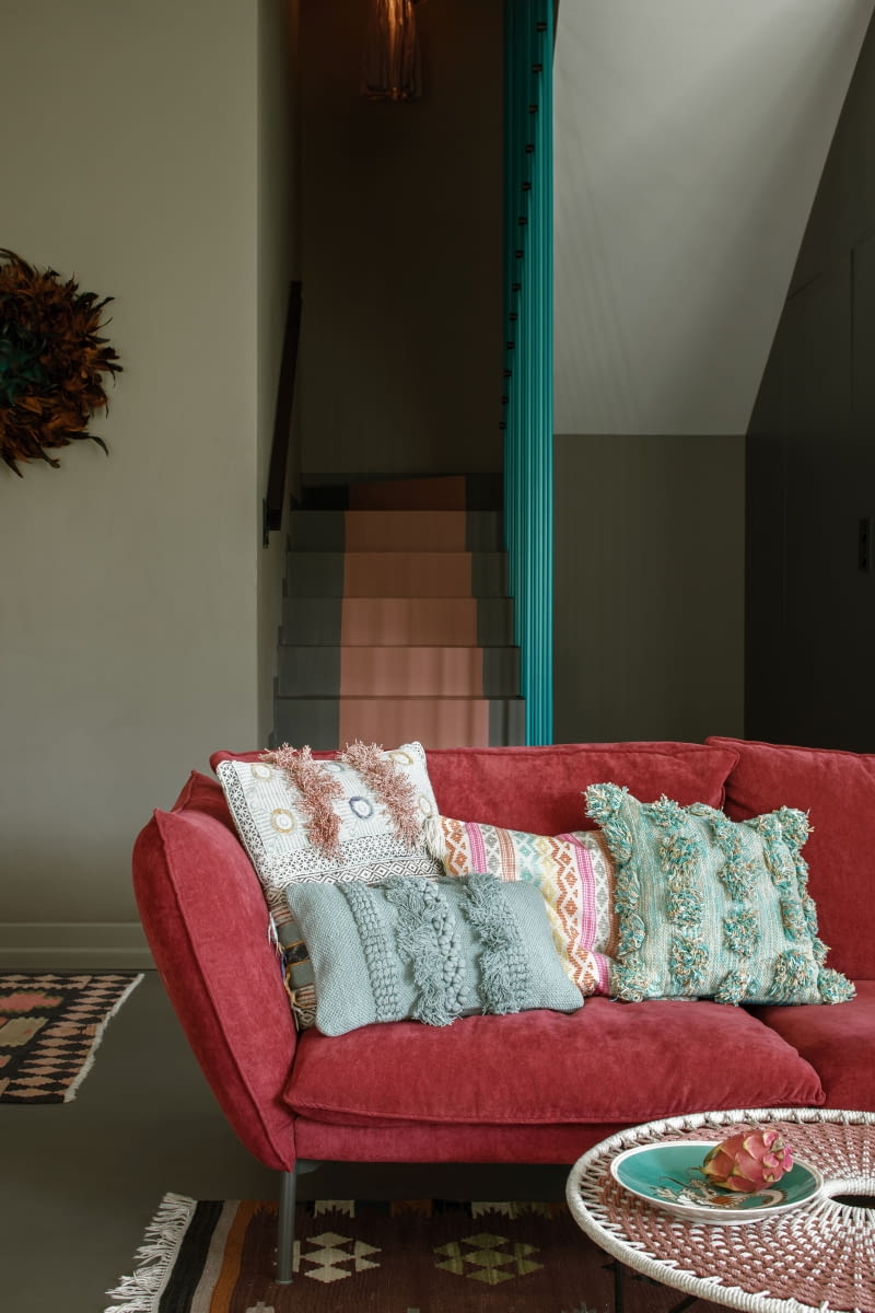 Ciepłe kolory i wyraziste wzory ożywiają przestrzeń, podkreślając jej radosny, energetyczny klimat. Sofa w malinowej tapicerce to mebel firmy Sits. Większość dywanów pochodzi ze sklepu Rugvista i od marki Carpet Vista.