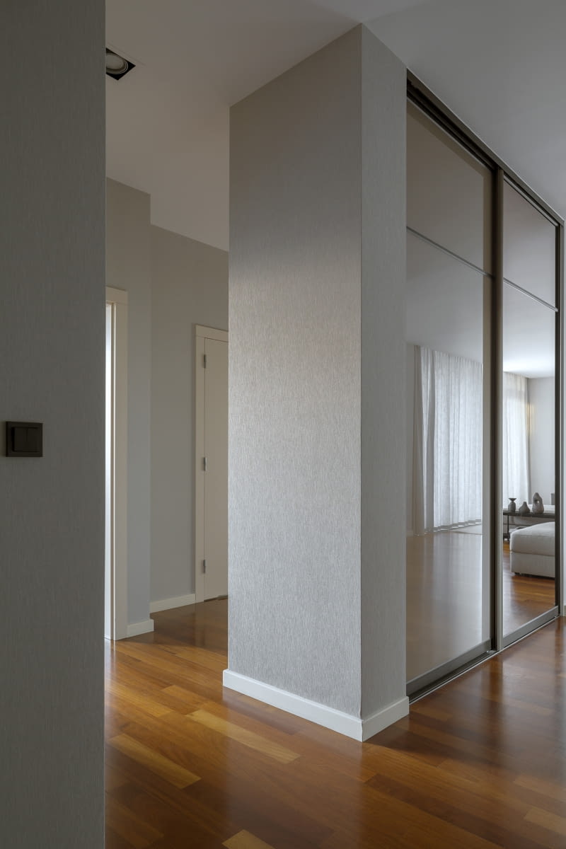 Wnękowa szafa w przedpokoju to jedyny mebel, który pozostał po poprzednich właścicielach. Skrzydła szafy pokryte odnowionymi lustrami odbijają światło, które dochodzi tu z okien i rozświetla korytarz aż do samych drzwi wejściowych.