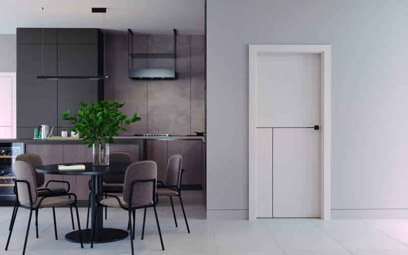 Dzięki subtelnej integracji drzwi ze ścianą i aranżacją kuchni wnętrze wygląda bardziej przestronnie i spójnie, a znajdujące się tu drzwi stają się mniej widoczne.
